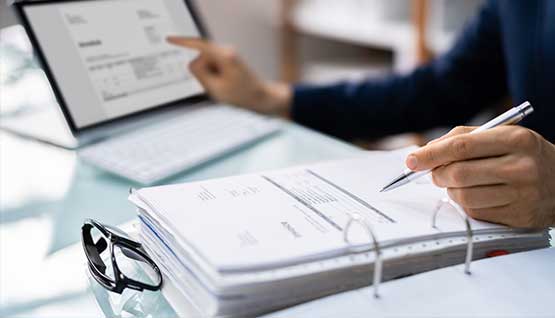 A business owner reviews paper invoices.