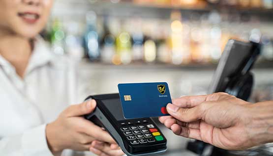 A business owner uses the First Business Mastercard to make a purchase.
