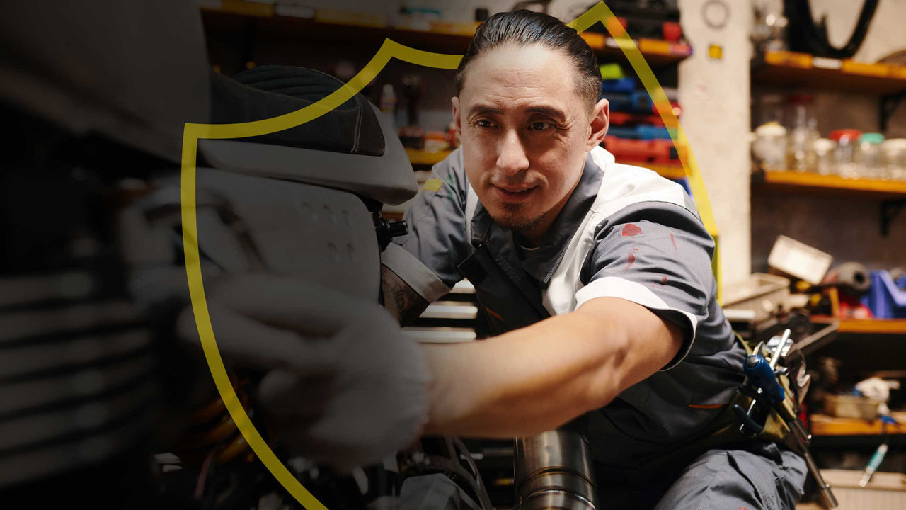 A motorcycle shop owner wraps up work on a roadster.